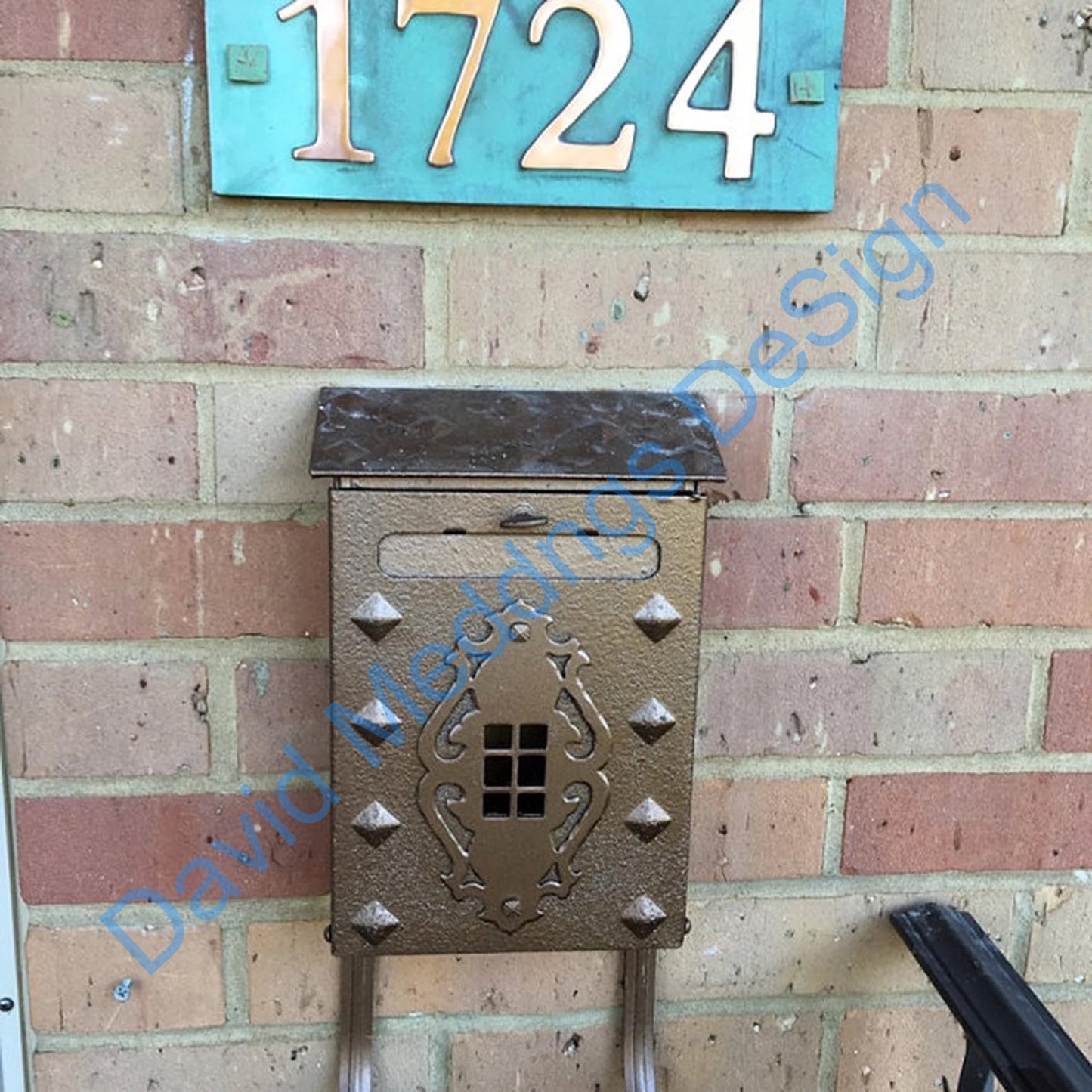 Traditional green copper plaque above mailbox