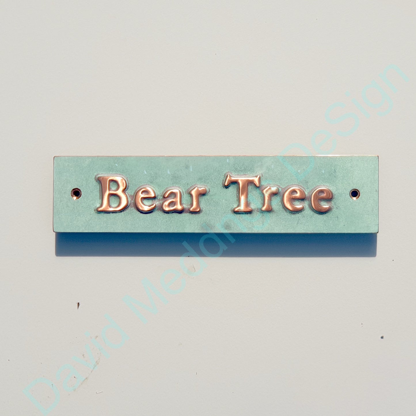 Decorative sign with 'Bear Tree' text on a copper background