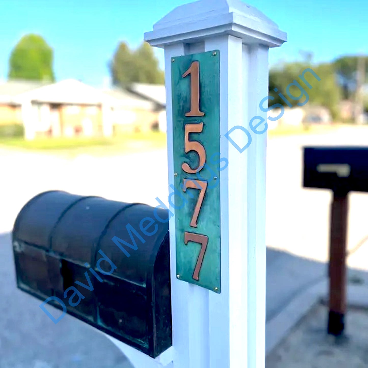 Green copper plaque on white post