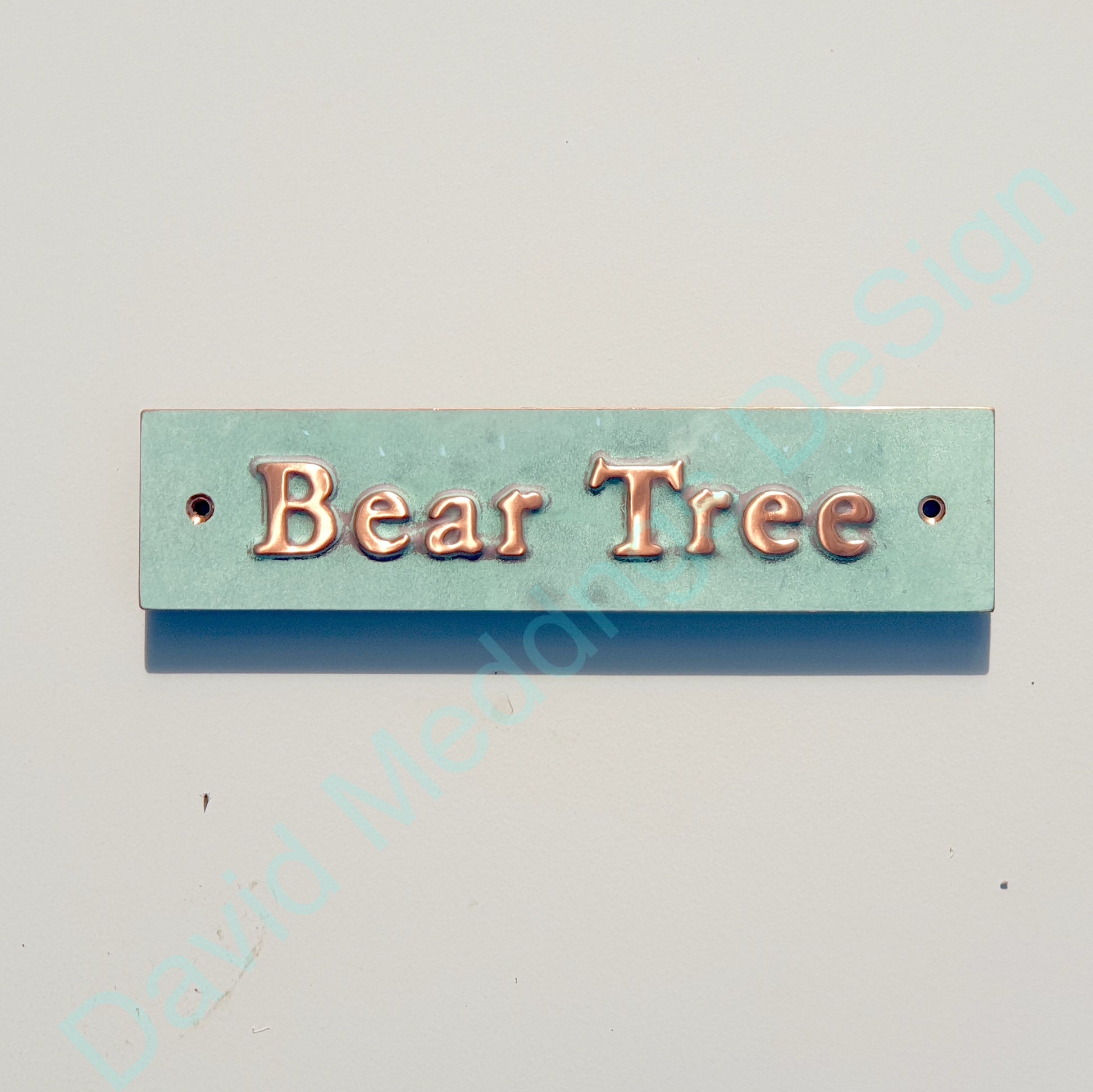 Decorative sign with 'Bear Tree' text on a copper  background