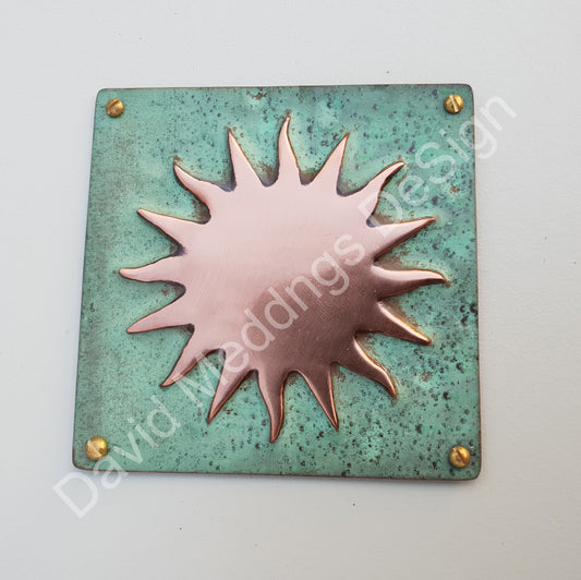 "Decorative copper embellishment plaque featuring a sun star design, representing solar astronomy, available in hammered or green copper finishes."